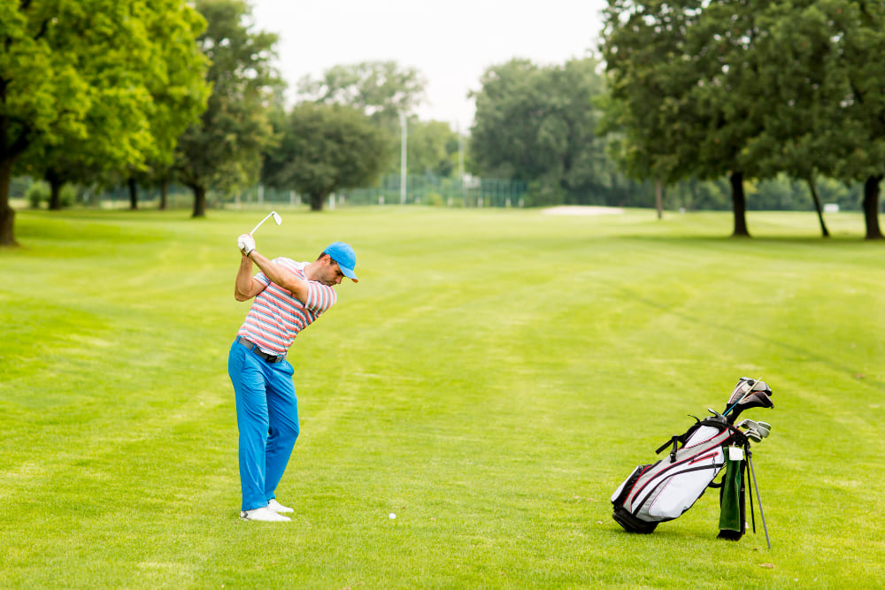 Mężczyzna w turkusowych spodniach gra w golfa